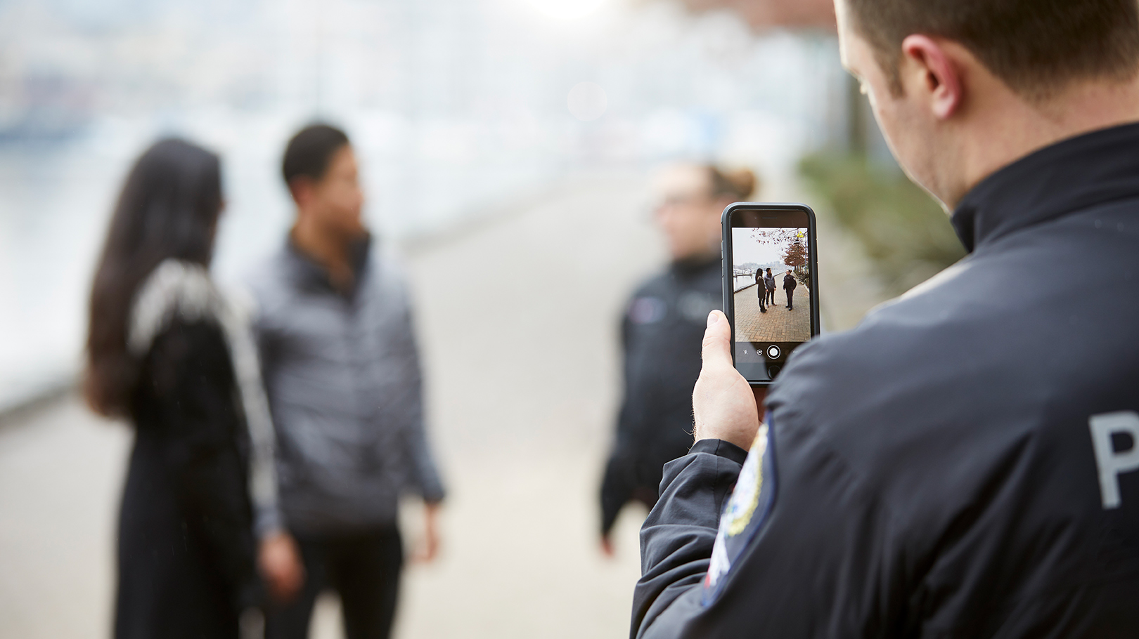An officer gathers evidence using Axon Capture, a smartphone application An officer gathers evidence using Axon Capture, a smartphone application